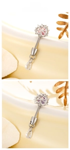Detail of star-shaped titanium steel navel rings with pink and purple zircons and teardrop pendants