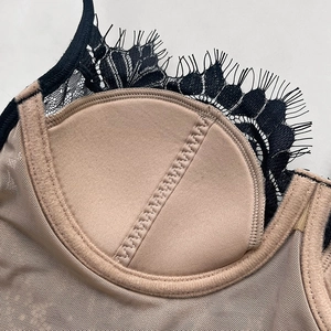 Lace bralette detail with nude padding and black eyelash lace trim in close-up shot