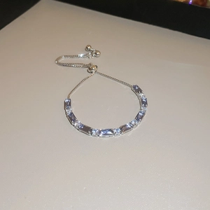 Gros plan du bracelet argenté avec zircons carrés violet clair et blancs sertis