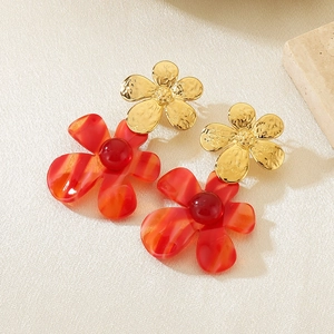 Detail of red floral earrings with gold metal small flower and translucent petals
