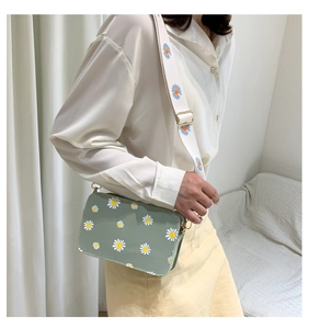 Detail of light green daisy printed crossbody bag with wide embroidered floral shoulder strap