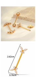 Macro shot of titanium nipple ring with gold finish and butterfly zircon detail