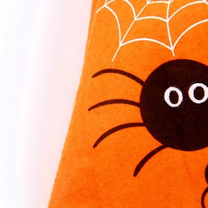 Close-up of bright orange non-woven fabric featuring black spider and white web patterns