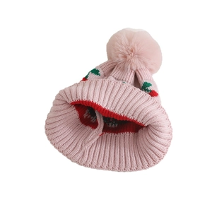 Pink knit beanie for toddlers with cherry patterns and a fluffy pom pom for winter warmth