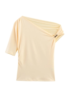 Detail of cream one shoulder top featuring elegant ruching and golden metal ring hardware
