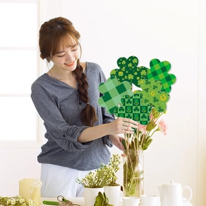 St. Patrick's Day clover floral picks being arranged in a flower vase at home