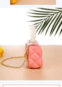 Detail of pink jelly crossbody bag with quilted pattern and large pearl handle