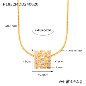 Macro detail of gold cylinder pendant necklace with three rows of clear zircon stones
