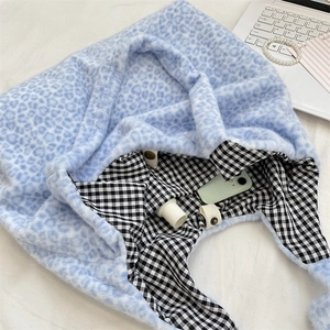 Detail view of the plush leopard print tote bag interior with checkerboard lining