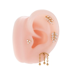 Gold-plated titanium leaf and crown labret earrings set with cubic zirconia on ear model