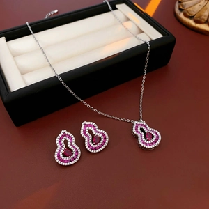 Detail of silver gourd necklace and earrings with red gemstone in a jewelry gift box