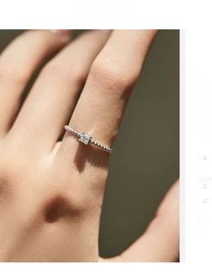 Detailed close-up of S925 sterling silver ring with square moissanite and beaded band design