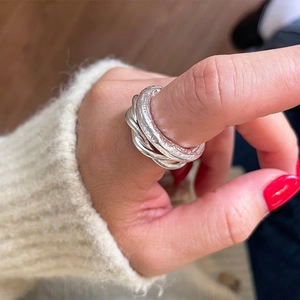 Close-up of a 925 sterling silver ring with irregular hammered texture on model hand