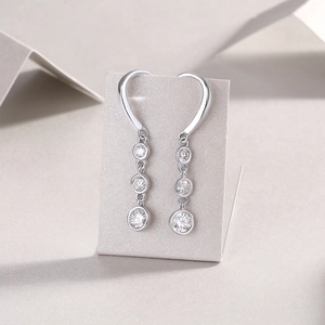 Macro detail of drop earrings with three round-cut sparkling cubic zirconia in silver