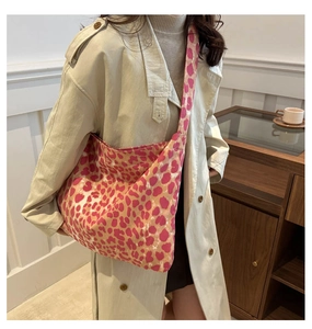 Gros plan d'un sac fourre-tout en toile imprimé léopard rose porté à l'épaule