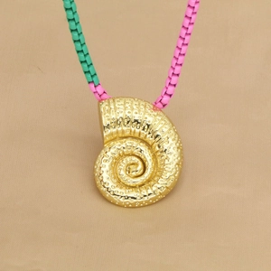 Golden conch pendant beaded necklace with pink and green accents on beige fabric