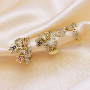 Gold plated copper ring set with sparkling cubic zirconia charms on beige silk fabric