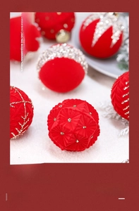 Close-up of red flocked Christmas balls with hand-painted snowflakes and sparkling rhinestones