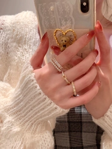 Detail of stacked gold S925 silver rings with pearls and zircons on a model's hand