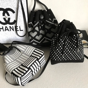 Knitted drawstring bucket bags with heart, polka dot and stripe patterns in black and grey