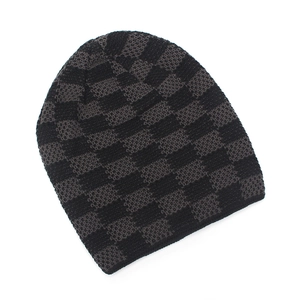 Close-up of black and grey checkered knit pattern on winter fleece-lined beanie