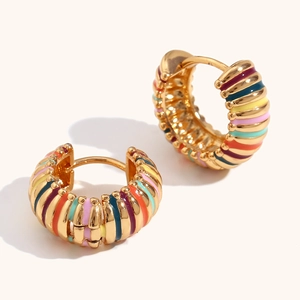 Detail view of gold-plated hoop earrings with vibrant rainbow enamel stripes and glossy finish