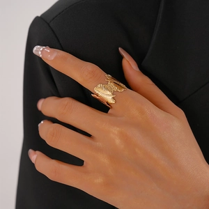 Macro detail of golden feather textured open ring showing intricate metallic patterns