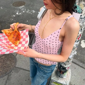 Pink polka dot camisole with V-neck detail shown in a casual lifestyle street style shot