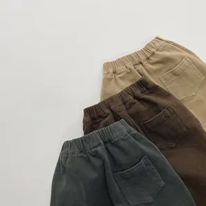 Detail of fleece-lined kids' trousers with elastic waistbands in khaki and brown colors