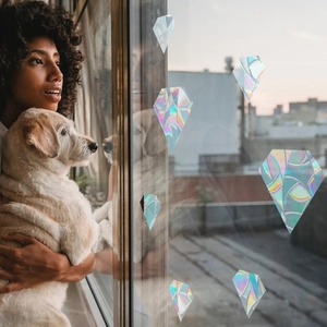 Holographic diamond window decals creating rainbow prism light in a cozy home setting