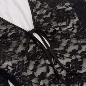 Close-up of intricate black floral lace texture with elegant ribbon tie detail