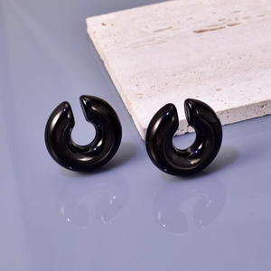Macro shot of minimalist hollow black chunky hoop earrings with mirror finish
