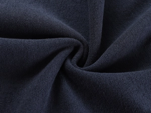 Macro shot of dark navy crepe fabric texture with elegant spiral draped folds