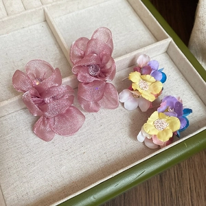Detail of pink and colorful chiffon fabric floral earrings on a jewelry tray