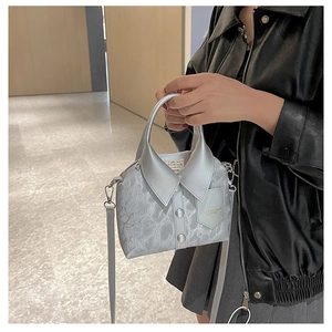 Detail of silver shirt-shaped handbag featuring collar, buttons and shoulder strap