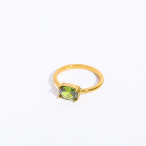 Detailed close-up of a gold ring featuring an oval green zircon stone inlay