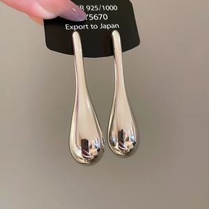 Macro detail of teardrop earrings showing 925 silver hallmark and polished mirror finish