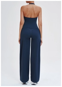 Detail of navy blue backless yoga top and high-waisted flared pants on a model