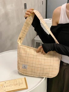 Women's yellow plaid wool shoulder bag with SR logo label shown in casual indoor setting