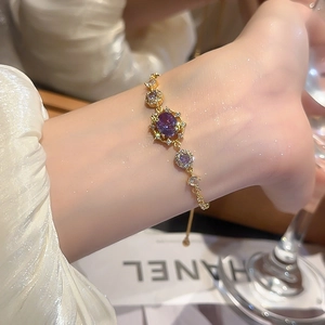 Detail of 18k gold plated bracelet featuring an oval purple zircon and adjustable sliding clasp