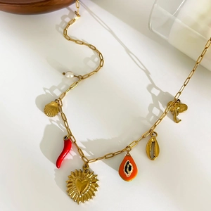Bohemian 18K gold plated necklace with heart shells and chili charms on white surface