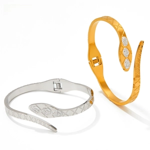 Detail view of gold and silver snake head bracelets with crystal pavé and spring hinge