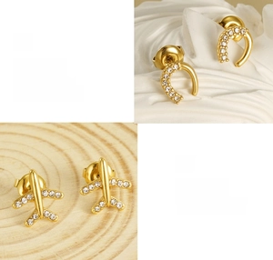 Vue macro détaillée de boucles d'oreilles avion et fer à cheval en or 18 carats avec zircons