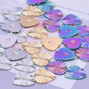 Polished stainless steel heart pendants in gold, silver, and rainbow finishes on purple background