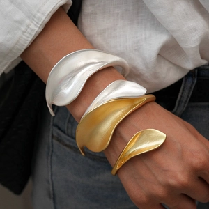 Metallic leaf-shaped open cuff bracelets in polished silver and matte gold finishes