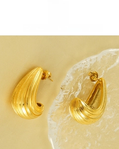 Macro shot of 18K gold plated C-shaped earrings with parallel geometric stripe texture
