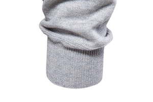 Macro view of grey knitted sweater sleeve with ribbed cuff detail and fine texture