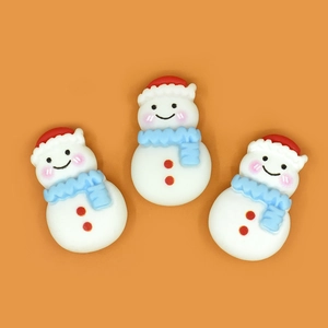 Close-up of three cute resin snowman charms with red hats and blue scarves for DIY crafts