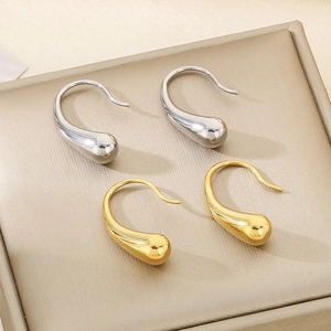 Polished stainless steel teardrop earrings in gold and silver on a jewelry tray