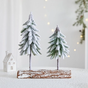 Mini snow-flocked Christmas tree set on natural wood base for festive tabletop decor